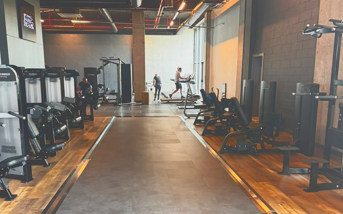 Hammer Strength makinelerinin dizildiği, ahşap ve beton zeminli geniş antrenman alanı
